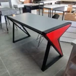 میز تحریر مدل فلش AVI-DE028  با بدنه MDF و پایه فلزی پروفیل با رنگ کوره‌ای میز تحریر MDF با پایه فلزی پروفیل با رنگ کوره‌ای محصولی شیک و مقاوم برای فضاهای اداری و خانگی است. ترکیب سطح MDF با کیفیت بالا و پایه‌های فلزی پروفیل که با رنگ کوره‌ای پوشش داده شده‌اند، ظاهری مدرن و صنعتی به میز بخشیده است. روکش مقاوم MDF در برابر خش و فشار، همراه با فرم خاص پایه‌ها که با زاویه و رنگ‌بندی جذاب طراحی شده‌اند، جلوه‌ای متفاوت و نو به فضا می‌بخشند. این میز مناسب قرارگیری لپ‌تاپ، نوشت‌افزار و لوازم تزئینی بوده و با هر نوع دکوراسیون مینیمال و مدرن هم‌خوانی دارد. کیفیت ساخت بالا، طراحی خاص پایه‌ها و پوشش مقاوم رنگ کوره‌ای موجب استحکام و دوام طولانی‌مدت میز شده است. سطح کار صاف و یکدست بوده و پایه‌ها به نحوی طراحی شده‌اند که علاوه بر حفظ تعادل، زیبایی هندسی خاصی ایجاد می‌کنند. میز تحریر MDF با پایه فلزی پروفیل با رنگ کوره‌ای گزینه‌ای مناسب برای کسانی است که علاوه بر کارایی، به زیبایی و دوام محصول اهمیت می‌دهند. این میز انتخابی دقیق برای دفاتر خلاق، اتاق‌های مطالعه یا فضاهای آموزشی مدرن است. ویژگی‌های محصول سطح MDF مقاوم و ضد خش پایه فلزی پروفیل با رنگ کوره‌ای طراحی مینیمال و زاویه‌دار مناسب برای دکوراسیون مدرن سطح صاف برای کارهای روزمره مقاوم در برابر ضربه و فشار رنگ ترکیبی خاکستری و قرمز استحکام بالا در اتصالات فلزی ابعاد مناسب برای استفاده اداری امکان هماهنگی با صندلی‌های مدرن نقاط قوت محصول ترکیب جذاب متریال MDF و فلز پوشش رنگ کوره‌ای مقاوم و بادوام طراحی هندسی مدرن و خاص مناسب برای فضاهای خلاقانه پایه‌هایی با تحمل بالا و تعادل مناسب امکان استفاده روزانه با طول عمر زیاد ایجاد فضای کاری منظم و زیبا تنوع در کاربرد (خانگی و اداری) هماهنگی رنگ با دکورهای معاصر سبک صنعتی در قالبی شیک و امروزی